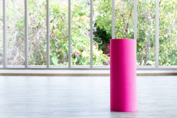 Розовый циновка yoga находится внутри комнаты
. - Фото, изображение