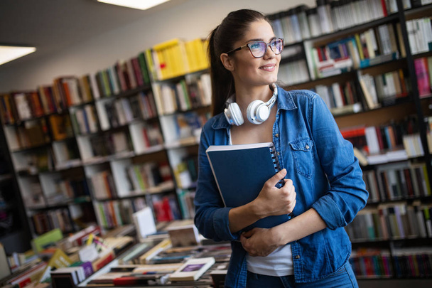 College woman studying at the library looking happy. Education concepts - Foto, Bild