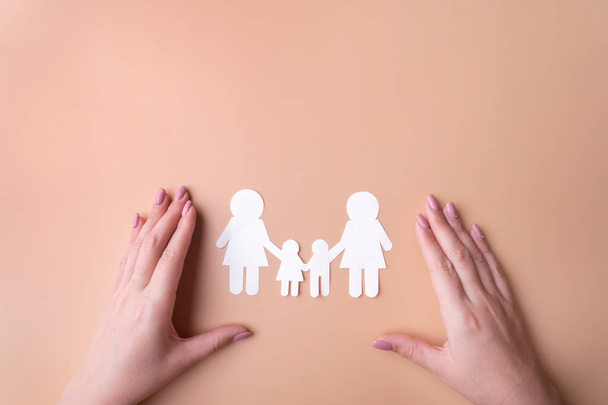 Symbol of same-sex family protection of sexual minorities, a family of white paper. Fashion female hands manicure. View from the top there is a place for inscription. Pink background. - 写真・画像