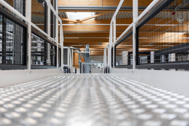Een metalen vloer en trappen bevinden zich in een fabriekshal. - Foto, afbeelding