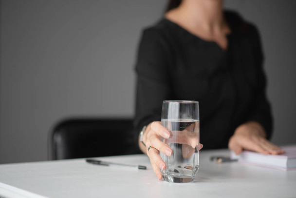 woman holds a glass of water in her hands. Office. Businessman. Close-up - Foto, Imagen