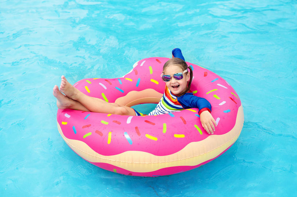 Child in swimming pool on donut float - Foto, Imagen