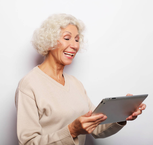 Happy starší žena pomocí tabletu, komunikuje s dětmi a vnoučaty - Fotografie, Obrázek