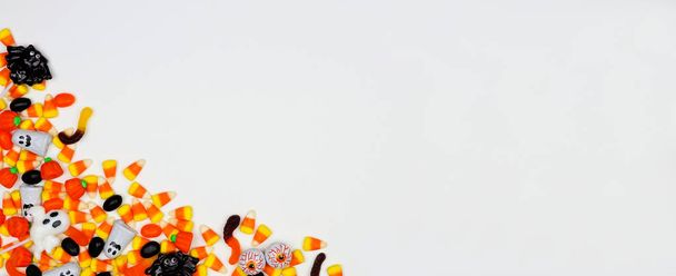 Halloween cukierki rogu granicy banner. Widok z góry na białym tle z przestrzenią kopiowania. - Zdjęcie, obraz