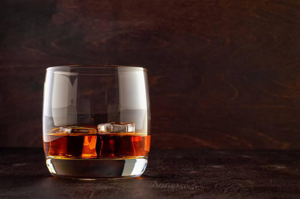 Glass of whiskey on a wooden table - Foto, imagen