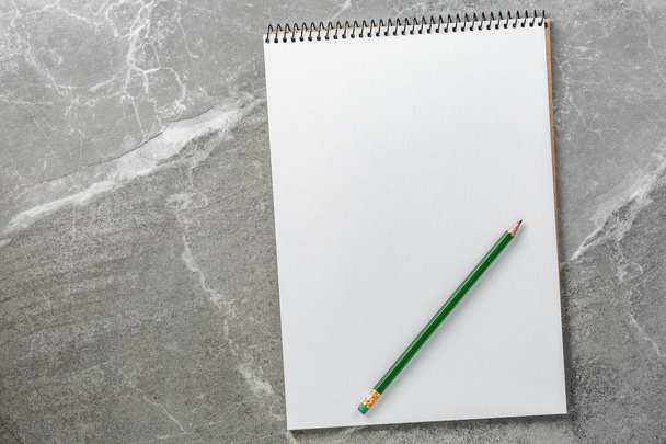 notebook zöld ceruzával márvány háttér, felülnézet - Fotó, kép