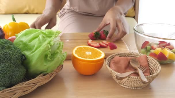 zbliżenie kobiety przygotowuje sałatkę owocową - Materiał filmowy, wideo