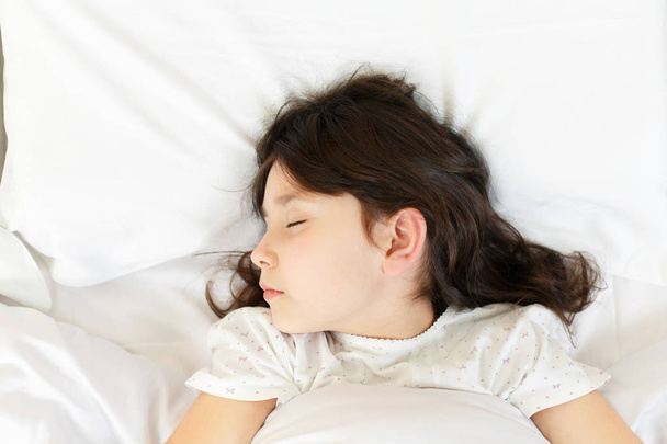 chica está durmiendo en limpio blanco suave cama - Foto, imagen