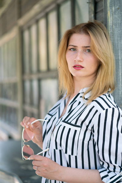 Portrait of a beautiful girl with bob haircut in a striped shirt walking outdoor - Φωτογραφία, εικόνα