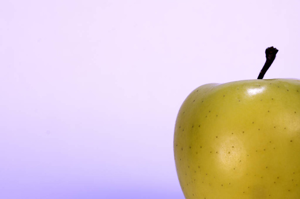 Half gele appel op een heldere achtergrond, vers fruit, appel - Foto, afbeelding