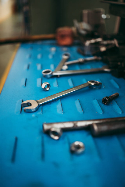 Close up shot of professional industry tools on grunge blue metal background. Industrial details suitable for design. - Foto, Bild