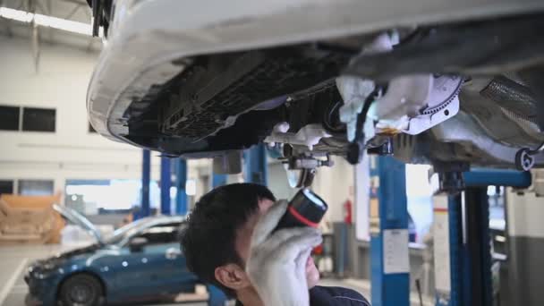 felvételeit ázsiai szerelőt vizsgálja autó a szolgáltató központ - Felvétel, videó