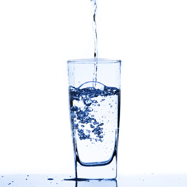 νερό χύστε από μπουκάλι νερό στο ποτήρι - Φωτογραφία, εικόνα