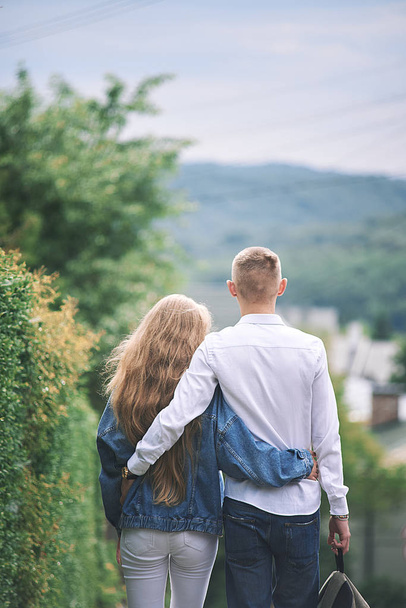 Νεαρό ζευγάρι στην αγάπη περπάτημα, στο καλοκαίρι πάρκο κρατώντας τα χέρια - Φωτογραφία, εικόνα