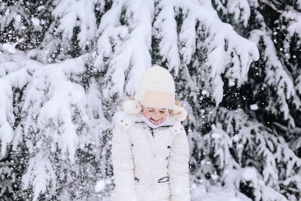 Портрет маленької дівчинки взимку. Тодлер грає зі снігом в
  - Фото, зображення