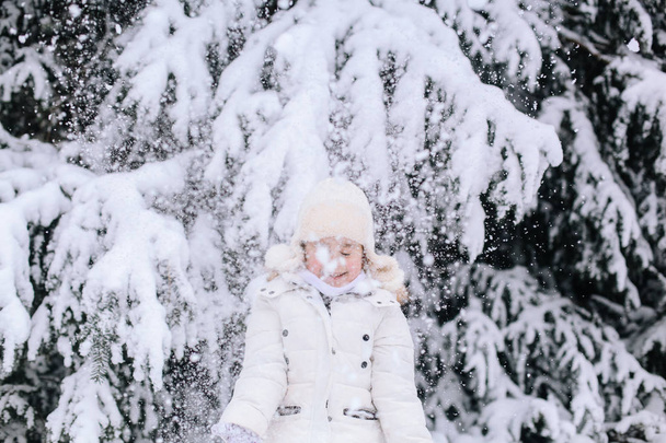 Portrait de petite fille en hiver. Tout-petit jouant avec la neige dans
  - Photo, image