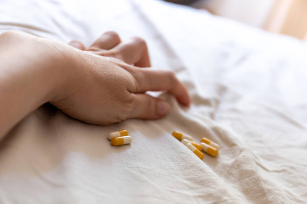 Close up hand of woman overdosing on medication. Close up of overdose pills in addict hand. Overdose concept. - Фото, зображення