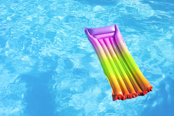 Colchão inflável colorido flutuando na superfície da água. Vista superior e espaço de cópia
 - Foto, Imagem