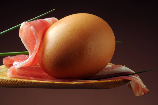 Huevo sin cocer con panceta en cuchara
 - Foto, imagen