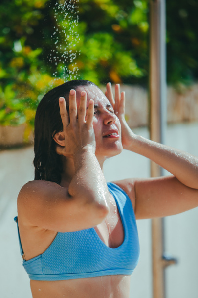 жінка приймає душ на морському пляжі. промити сіль водою
 - Фото, зображення