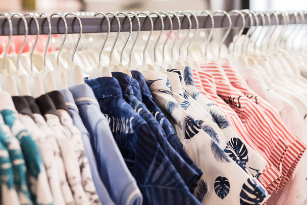 Le cintre à vêtements est rempli de chemises en tissu coloré
 - Photo, image