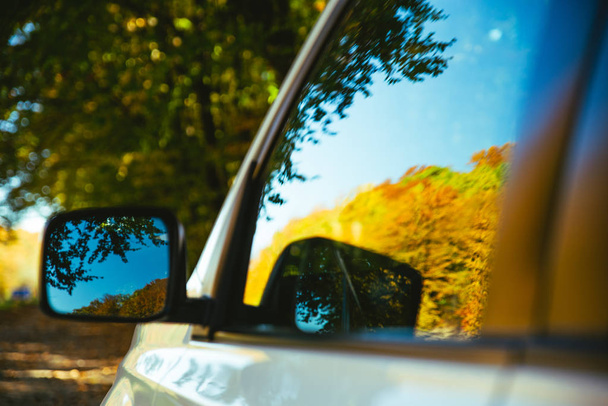 auto lähikuva heijastus keltaisia puita peilissä
 - Valokuva, kuva