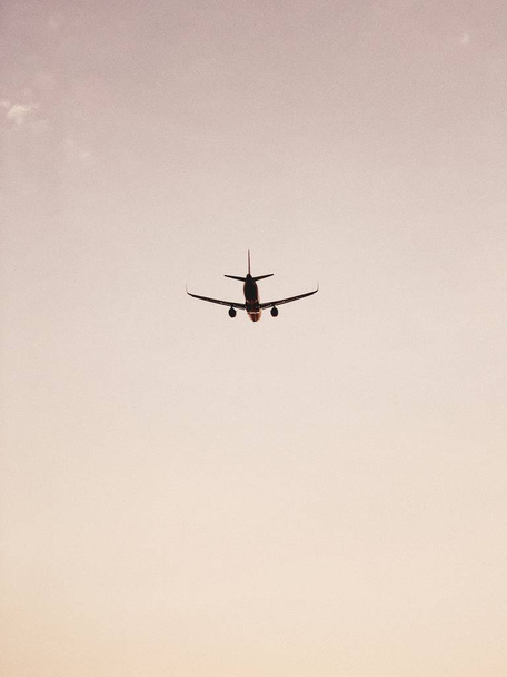 Airplane flying in the sky at sunset. Travel, vacation and holiday concept. Vintage and retro tones filter. - Foto, Bild