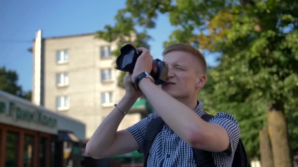 Fotógrafo olha para visor para tirar foto de uma atração
 - Filmagem, Vídeo