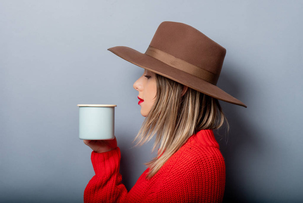 Frau in rotem Pullover und Hut mit Tasse Kaffee - Foto, Bild