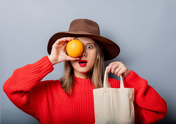 オレンジとバッグの赤いセーターの女性  - 写真・画像