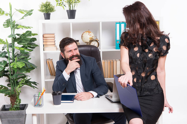 Loved by his employee. Sexy administrative employee and employer. Adorable woman employee sitting at desktop while man looking at her. Professional female employee at workplace against businessman - Photo, Image