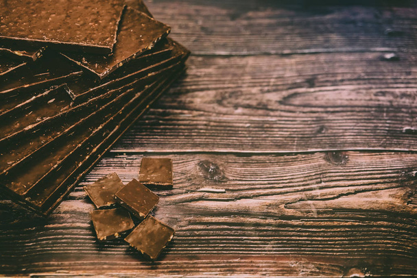 Многие деликатесы темный шоколад таблетки изолированы на деревянной спинке
 - Фото, изображение