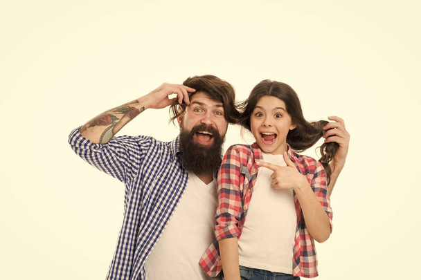 He envies my hairstyle. Man with beard and little girl long hair on white background. Father play with hair of kid. Hairdresser and barber concept. Having fun with long hairstyle. Hair care - Foto, Imagen