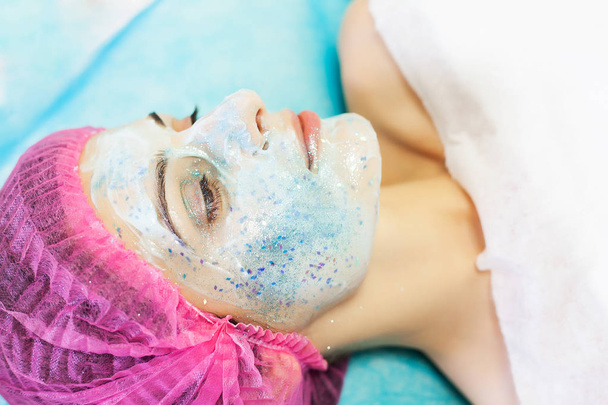 Terapia de spa para mujeres jóvenes que tienen máscara facial en el salón de belleza
. - Foto, imagen