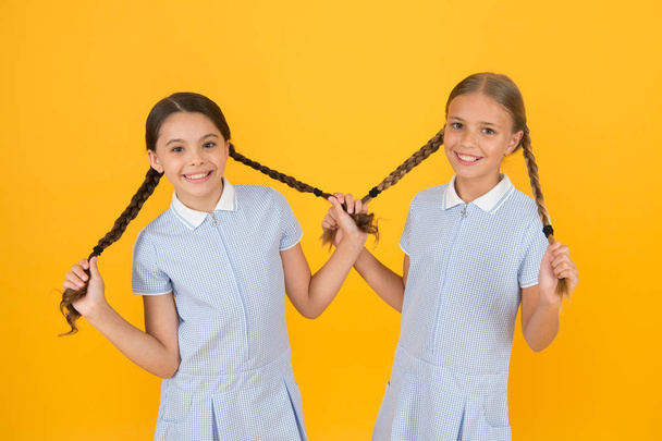Looking trendy. sisterhood concept. best friends. vintage style. small girls in retro uniform. old school fashion. back to school. happy beauty with pigtails. happy childhood. brunette and blond hair - Photo, Image