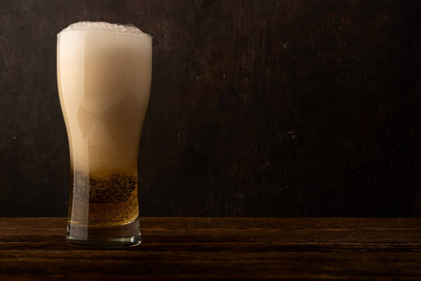 Cerveza de vidrio sobre fondo de madera oscura con copyspace
 - Foto, Imagen