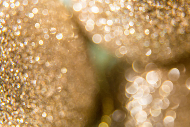 Golden beautiful blurred bokeh background with copy space. Shiny background. Wallpaper for web design. Christmas theme or other design. Holiday texture - Photo, Image