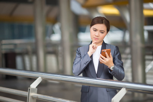 Businesswoman use smartphone and has nagative thinking - Photo, Image