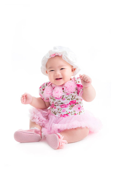 Volledige lengte van kleine baby meisje in zoete roze jurk zittend over Wit - Foto, afbeelding