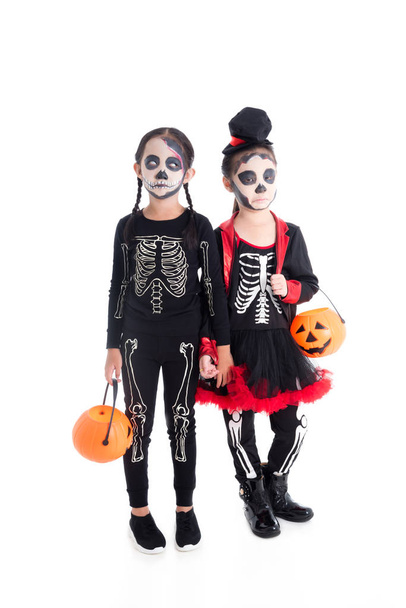 Pełna długość dziewczyn w kostiumie szkieletu trzymania Halloween dyni wiadro - Zdjęcie, obraz