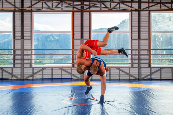 Oikeudenmukaisen painin käsite. Kaksi greco-roomalainen painijat urheilupainijat ja tekee heittää paini matto kuntosalilla.Käsite mies paini ja vastus
 - Valokuva, kuva