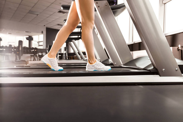 женские ноги, идущие на беговой дорожке в спортзале
 - Фото, изображение