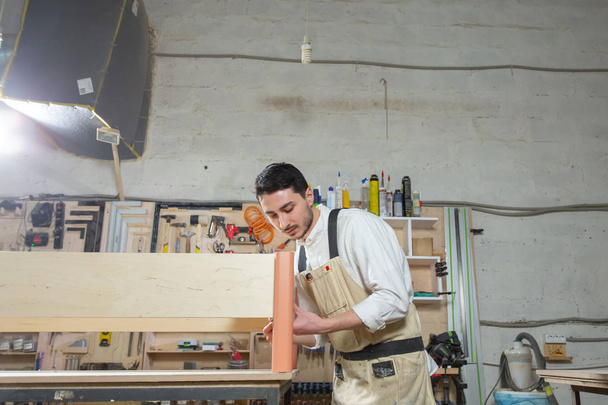 Pienet yritykset, kalusteet ja työntekijöiden käsite - Komea nuori mies työskentelee huonekalutehtaalla
 - Valokuva, kuva