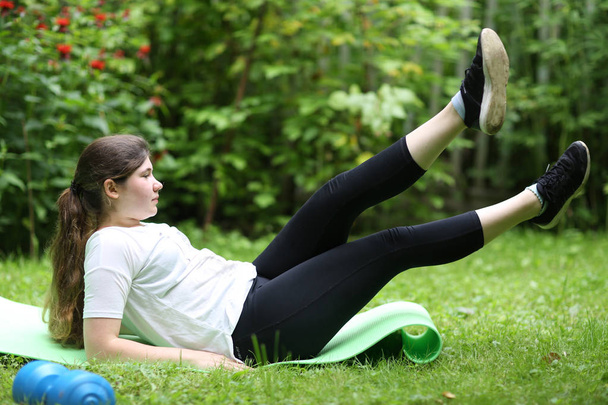 teenager girl lay exhausted on gym rag with dumbbell after train - Foto, Imagem
