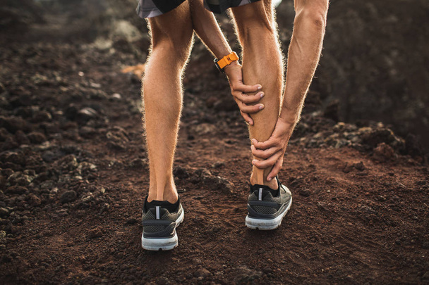 Erkek koşucu yaralı baldır kas tutarak ve ağrı ile acı. - Fotoğraf, Görsel