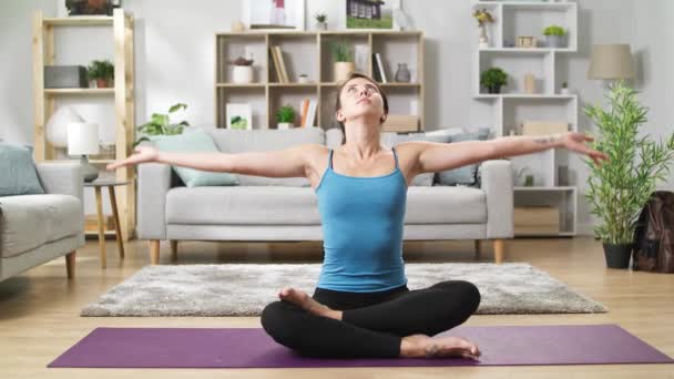 Yogi woman sitting on floor in living room and connect fingers in mudra - Πλάνα, βίντεο