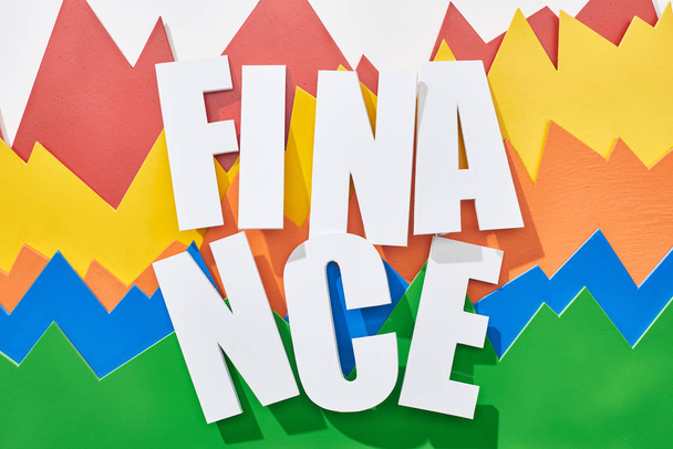 Draufsicht der Finanzinschrift auf weißem Hintergrund mit mehrfarbigen statistischen Diagrammen - Foto, Bild