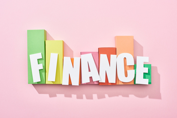 Draufsicht der Finanz-Inschrift auf rosa Hintergrund mit Farbblock-Diagramm - Foto, Bild