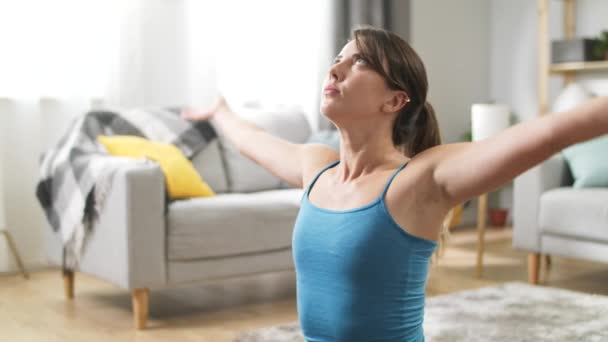 Medium shot of female yogi doing namaste in her living room - Πλάνα, βίντεο