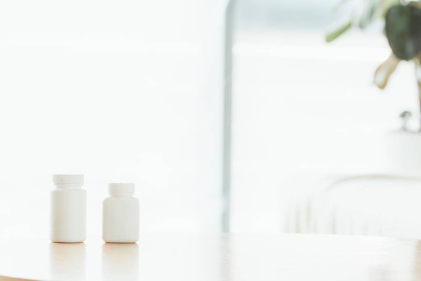 foyer sélectif de bouteilles blanches avec des pilules sur la table en bois
  - Photo, image